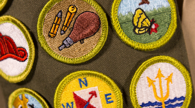 a collection of badged with various artwork on them